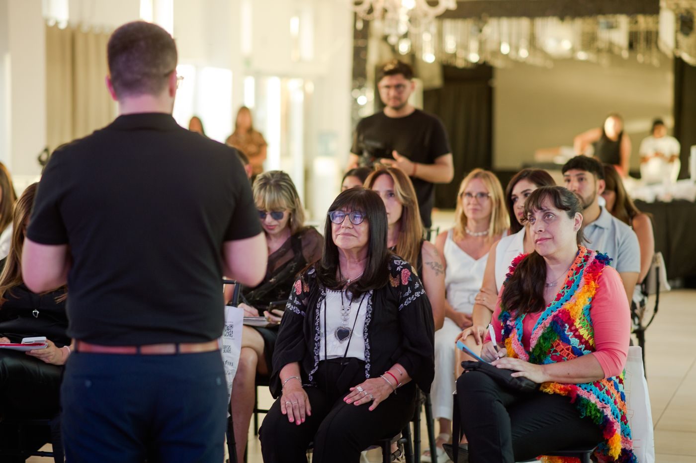 Participantes escuchan a un facilitador durante un encuentro